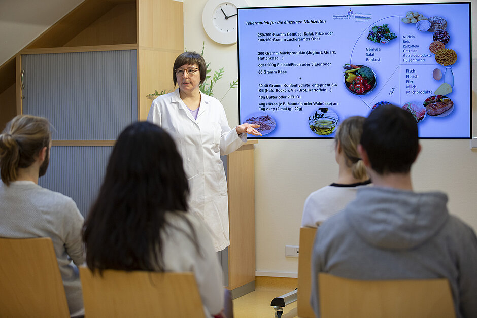 Eine Ernährungsberaterin hält eine Schulung für eine Gruppe von Menschen