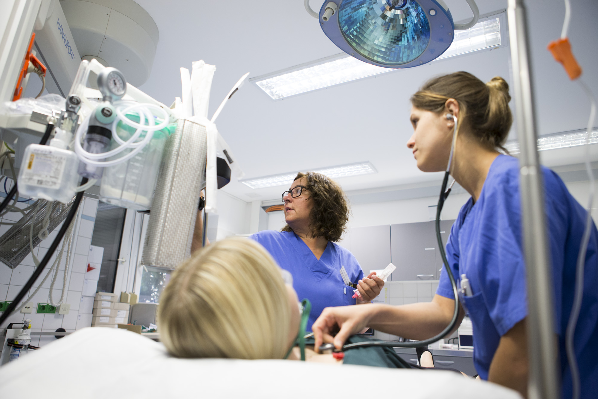 Zwei Ärztinnen versorgen eine Patientin im Behandlungsraum.