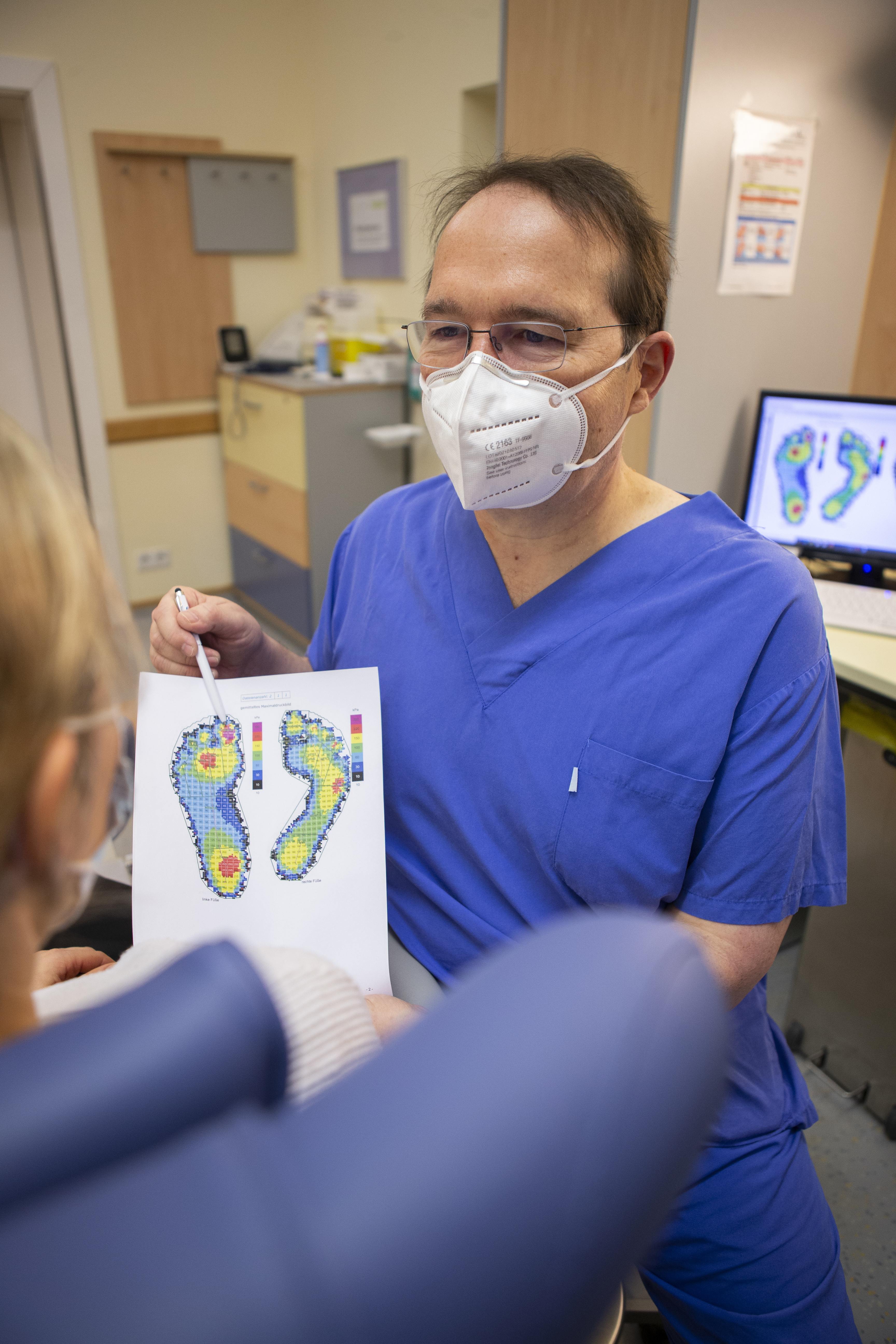 Ein Arzt bespricht eine Fußdruckanalyse